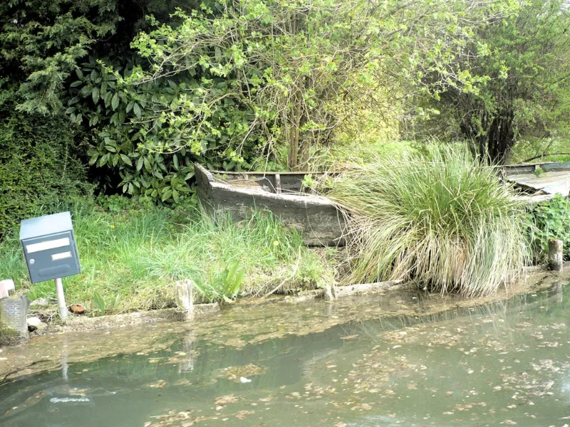 barque posée sur les berges d'une habitation dans les marais Audomarois